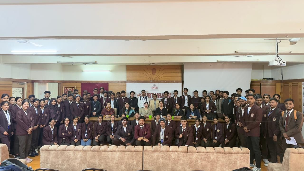 Anushikha Dwivedi on stage in front of a full college auditorium